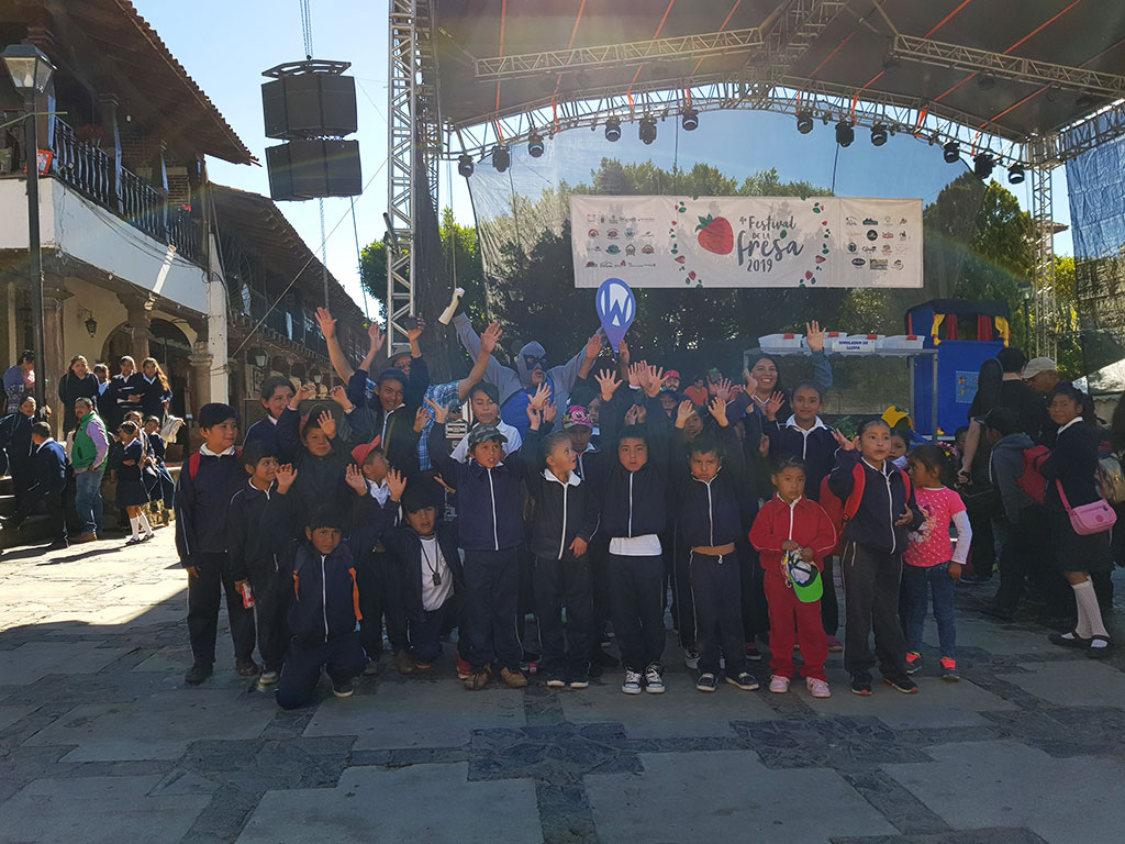 Waterman con un grupo de niños frente al escenario del festival de la fresa 2019